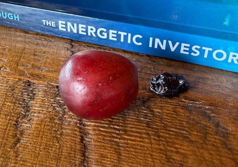 Red grape and raisin on wooden table.